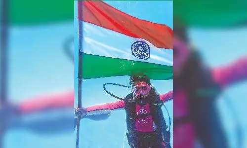 Diving instructor raises flag underwater for 17th time