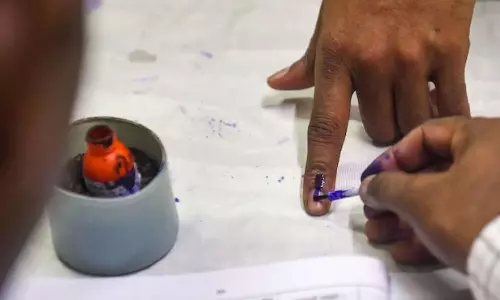 Independent candidate files papers with Rs 10 coins to create awareness against refusal of the denomination