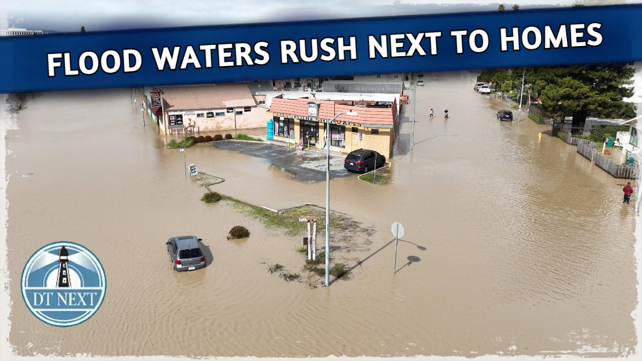 Flood waters rush next to homes in California Flood waters rush next to homes in California