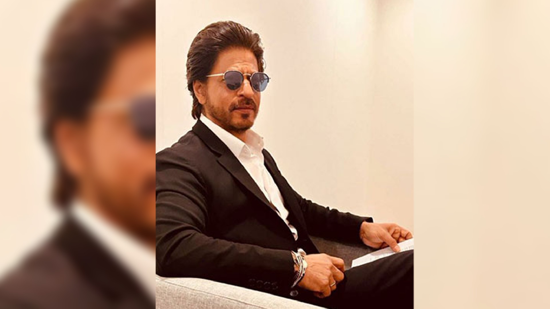 SRK pushes intruding fans hand aside as he walks out of airport SRK pushes intruding fans hand aside as he walks out of airport