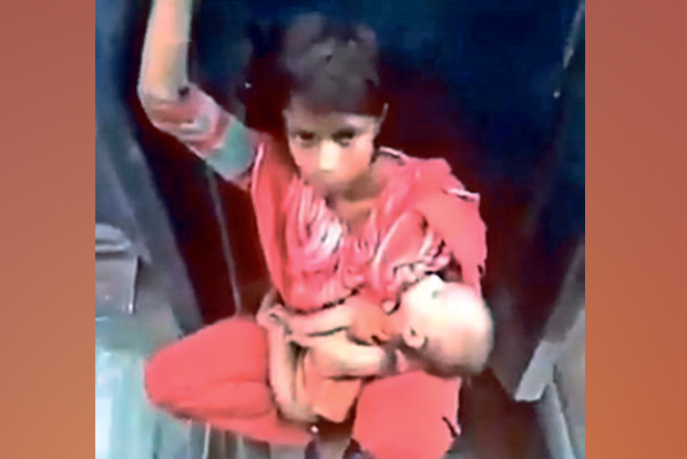 Detect: Woman sitting between train carriages not from India Detect: Woman sitting between train carriages not from India