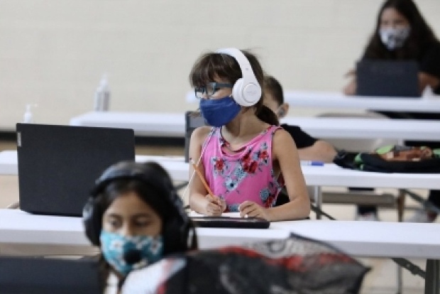 Scared by virus surge, more US schools suspend in-person classes