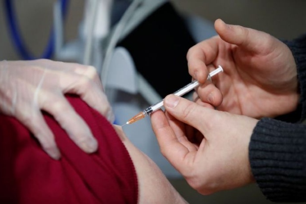 France gives hospital staff COVID shots as it plays catch-up with neighbours